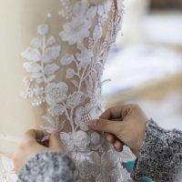 Hand sewing on wedding gown